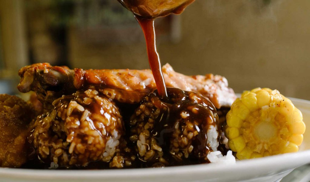 Plate lunch with rice, gravy, corn, and meat from a Lafayette, LA restaurant