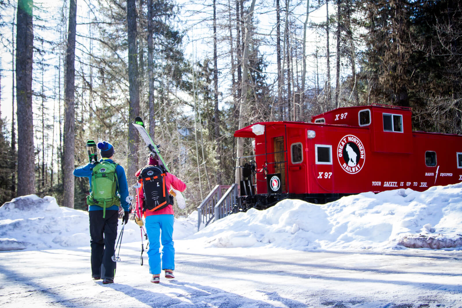 Two skiiers walking towards Izaak Walton Inn