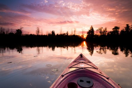 A kayak cuts through the water at sunset in Alpena County, Michigan.