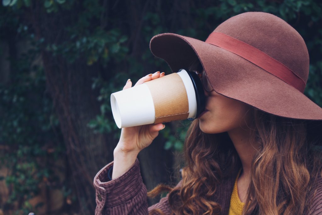 Woman drinking a to-go cup of coffee.