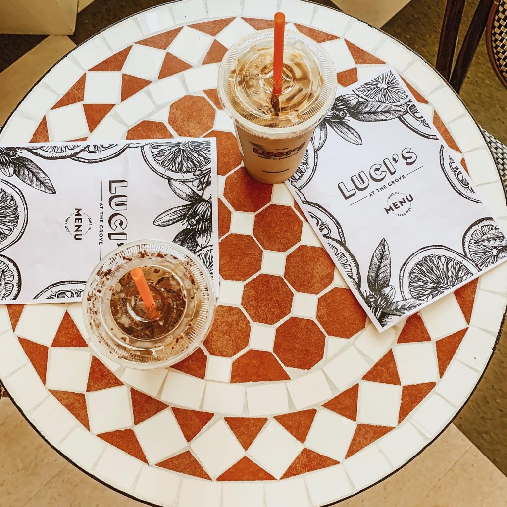 Two cups of iced coffee, and two Luci At The Grove menus sit atop a mosaic tabletop at Luci's in Scottsdale, Arizona.