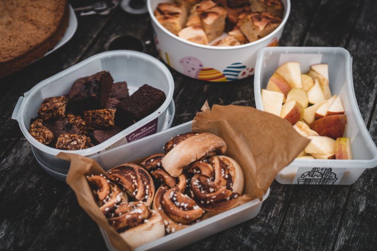 assorted snack mix including cinnamon rolls, brownies and apples.