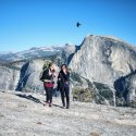 Two women laugh as they walk away from half dome
