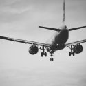 Black and White image of plane flying away