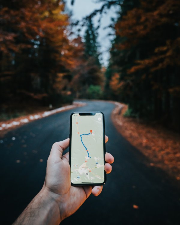 Hand holding a phone with a map app.
