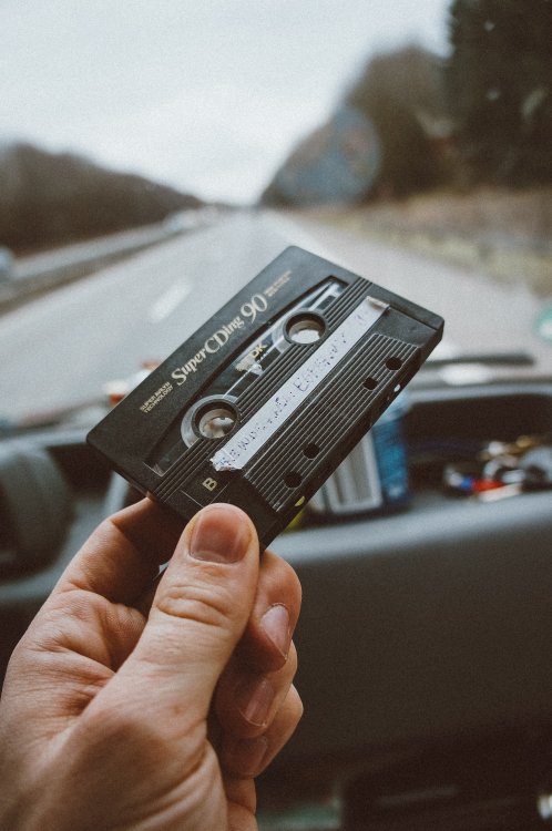 Hand holding up a casette tape.
